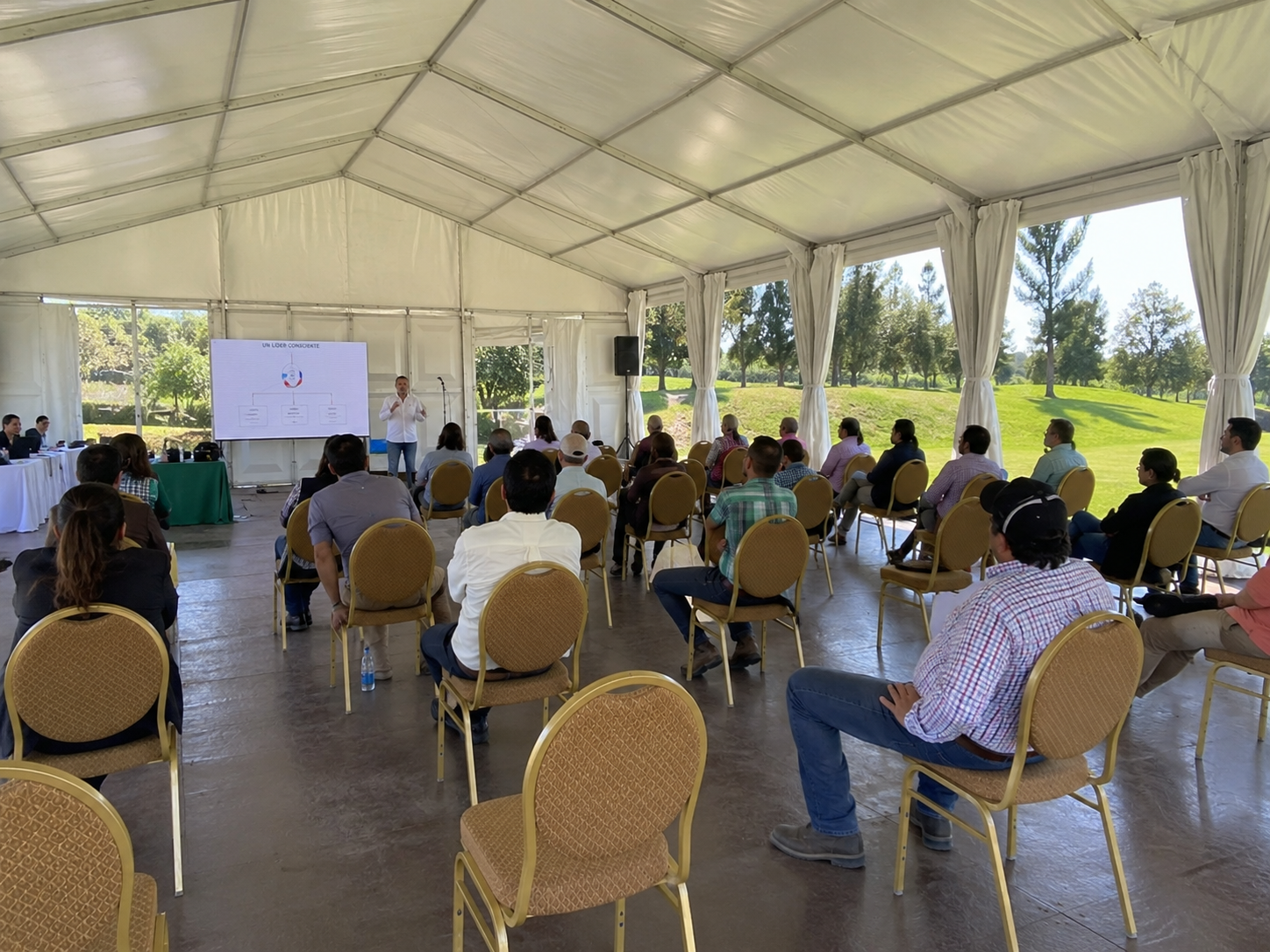 Carpa modular cerrada para presentación corporativa con sillas y pantalla interior