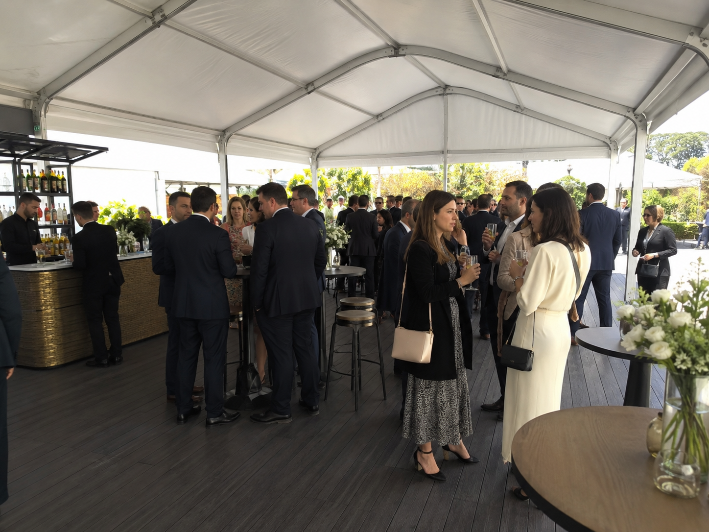 Carpa modular blanca con barra y asistentes en un evento de empresa