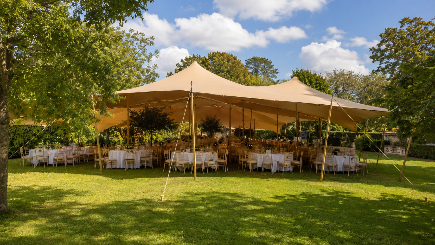 Carpa de boda con banquete montado vista desde el jardín