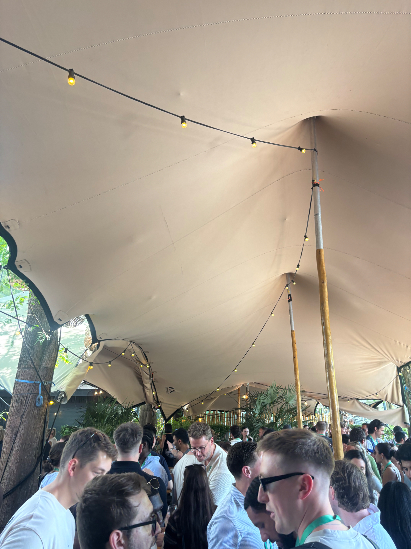 Interior de carpa tensada llena de asistentes