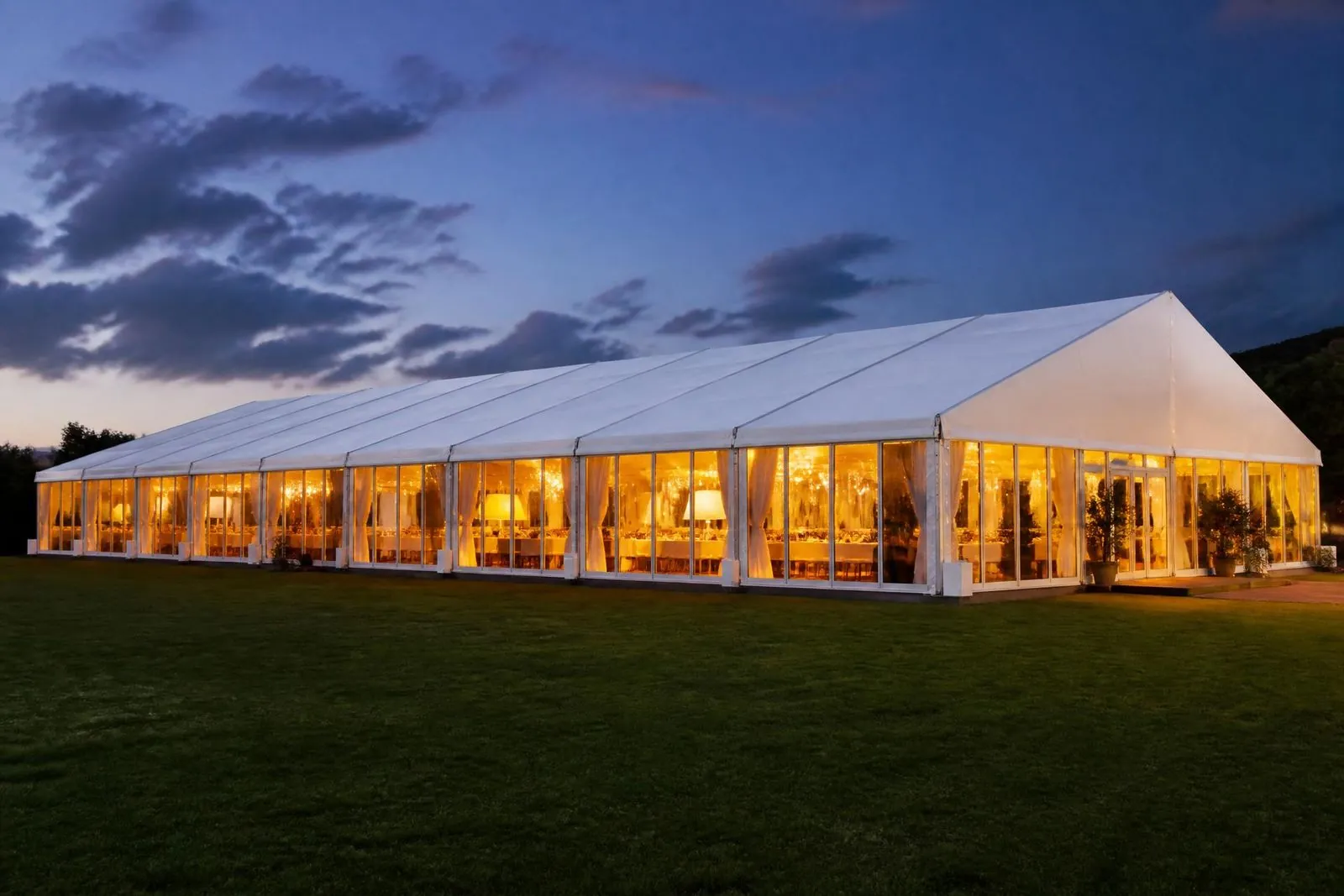Carpa modular iluminada por la noche en un evento de gran formato
